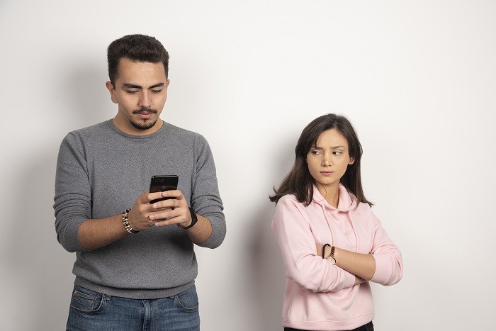 Young man playing with his telephone while his lover looking at - Advice